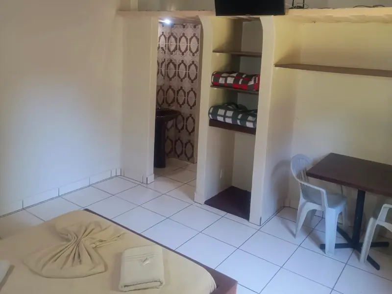 Ar-condicionado, televisão e mesa dentro da cabana