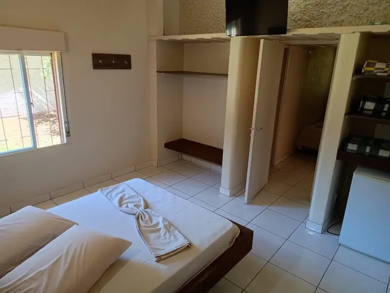 Cabana de família: cama de casal e porta para o segundo quarto