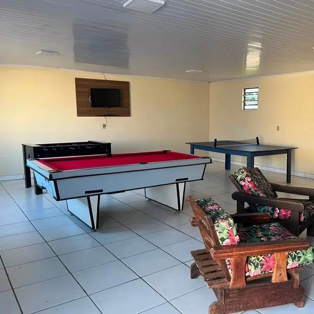 Sala de jogos com sinuca, ping-pong e televisão