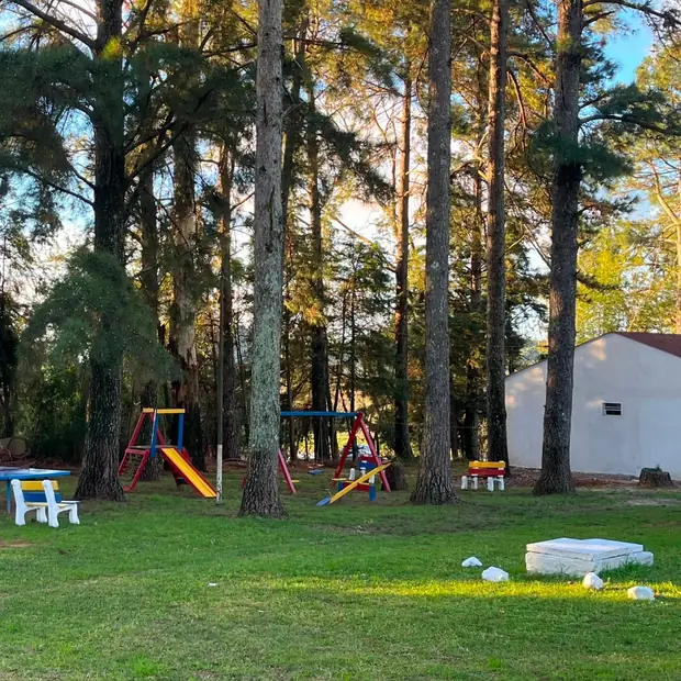 Balanço, escorregador e gangorra na área verde