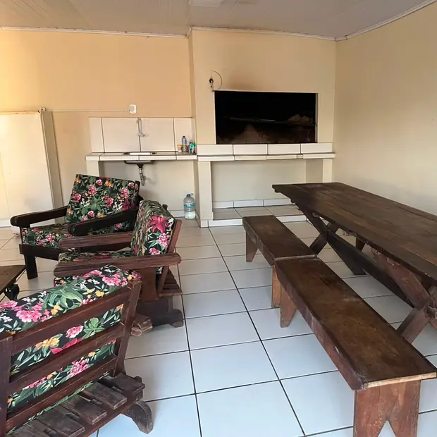Salão com churrasqueira e mesa grande