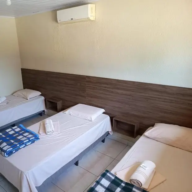 Quarto com três camas e ar-condicionado