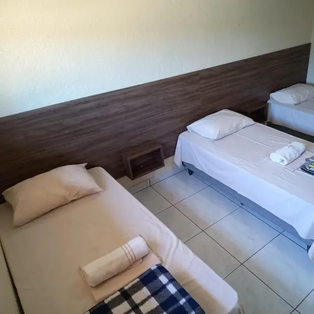 Quarto com três camas de solteiro